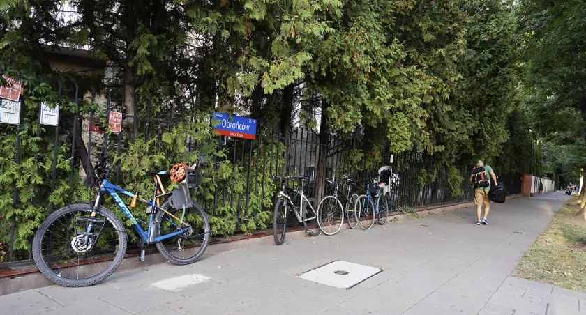 Kontenery na śmieci, samochody i rowery