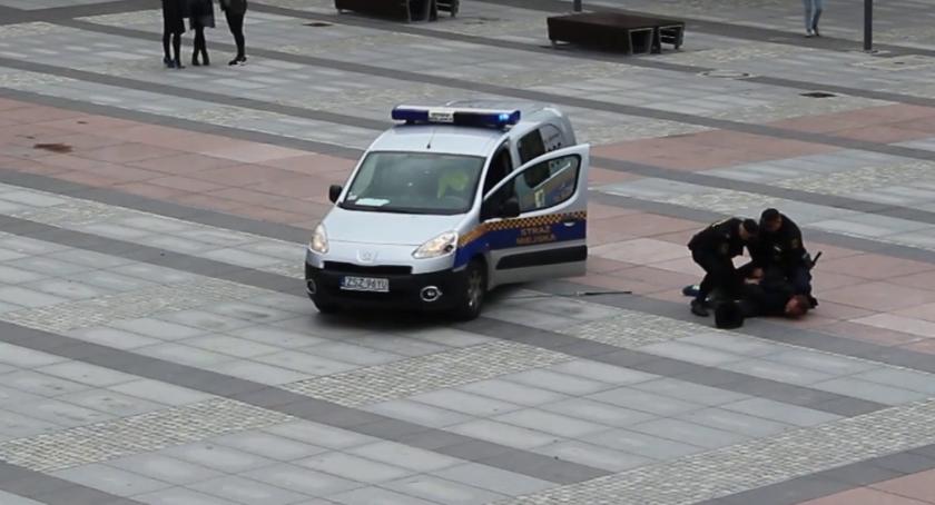 Człowiek z kijem na placu Wolności, 5 kanistrów schowanych w krzakach