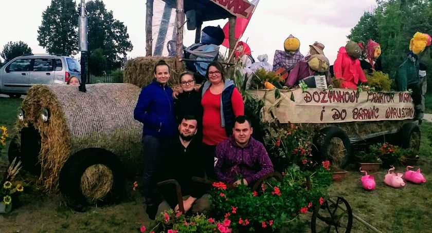Traktor z przyczepą, a na niej ludzie. Wszystko ze słomy. Super witacz dożynkowy w sołectwie Przeradz