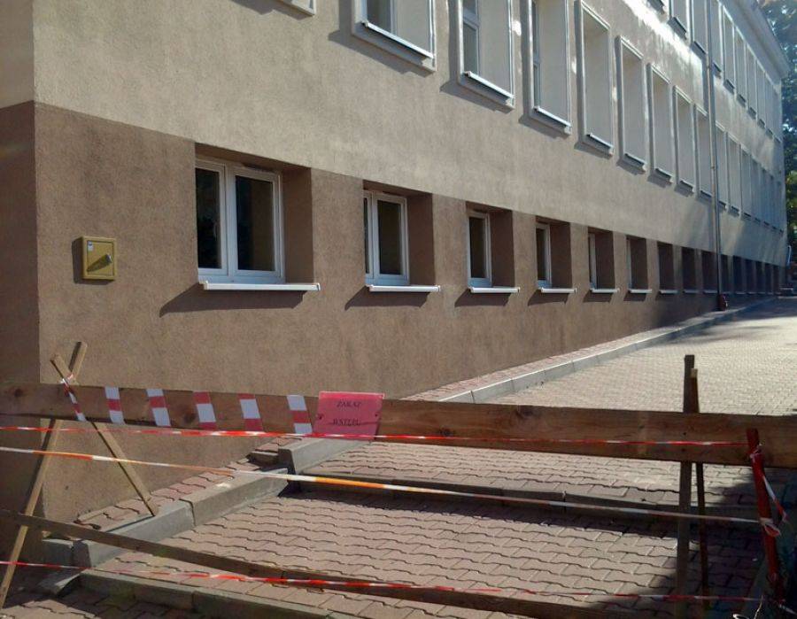 Spod dachu spadają kawałki gzymsu. Dzieci chodzą dookoła.[FOTO]