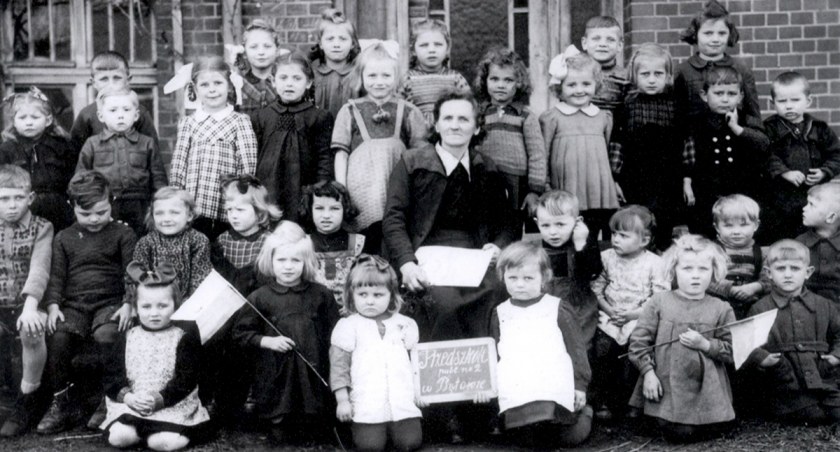 Stara fotografia dzieci i nauczycielki z Przedszkola nr 2 przy ul. Drzymały w Bytowie. Wykonano ją w 1948 r.