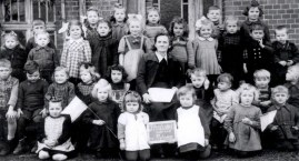 Stara fotografia dzieci i nauczycielki z Przedszkola nr 2 przy ul. Drzymały w Bytowie. Wykonano ją w 1948 r.