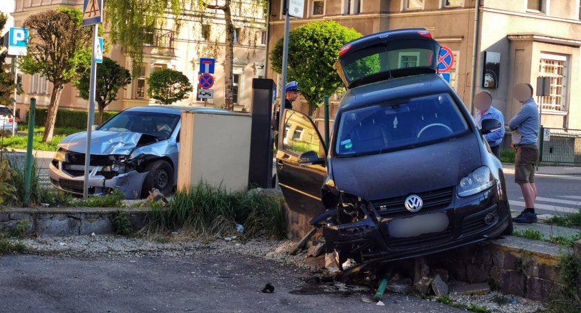 Zderzenie Hondy i Volkswagena. Golf staranował płot i wpadł na parking