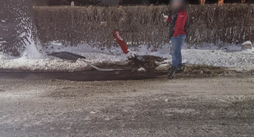 Samochód uderzył w hydrant. Woda wylewa się na jezdnię i natychmiastowo zamarza