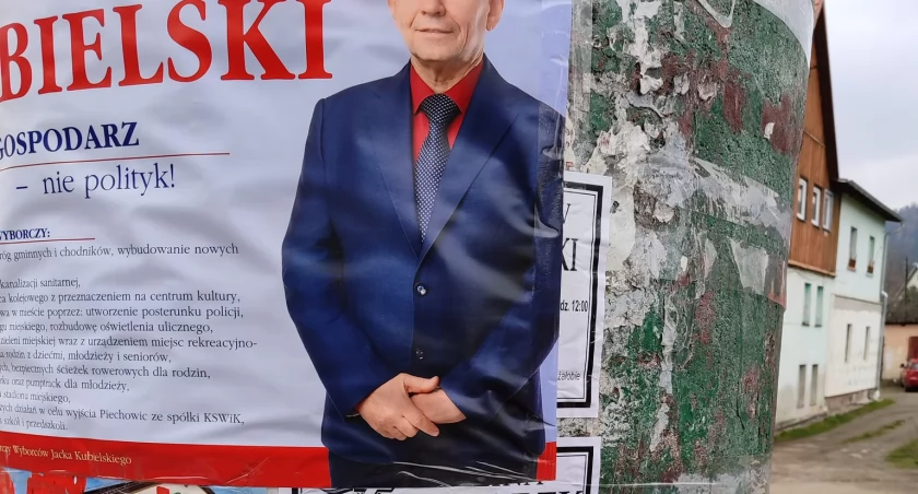 Plakat wyborczy na klepsydrach z nekrologami