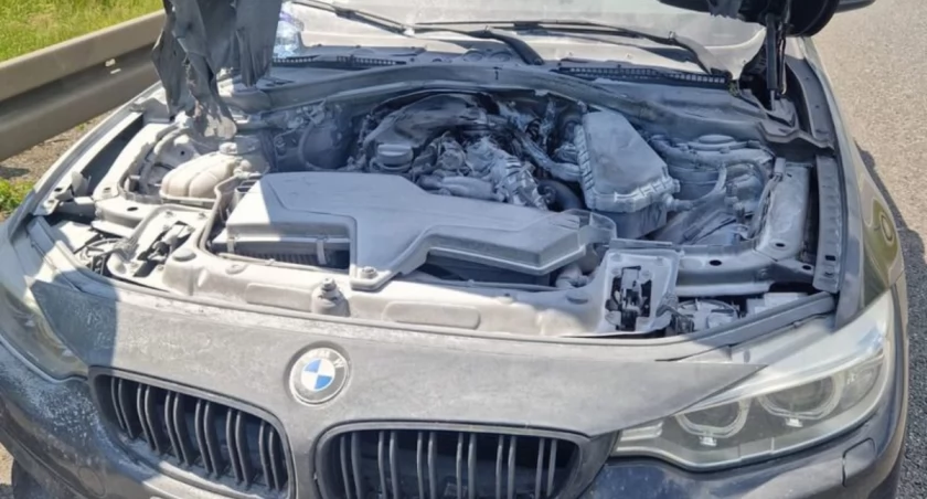 Ogień wydobywał się spod pokrywy silnika BMW. Policjanci ruszyli z pomocą