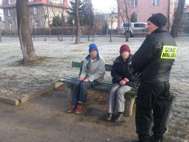 Wychłodzeni bezdomni na ławce w parku