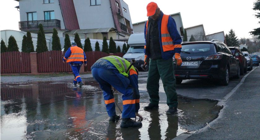 Awaria sieci wodociągowej. Wodnik naprawia usterkę.