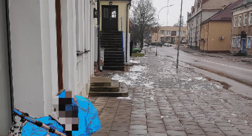 Dziecko w wózku pod sklepem