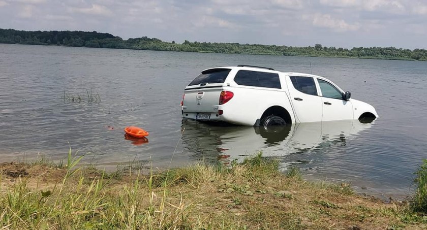 Strażacy wyłowili z wody samochód z przyczepą. Jak auto wpadło do zbiornika wodnego? [ZDJĘCIA/FILM]