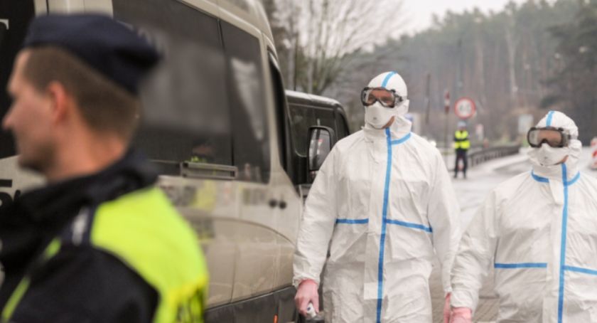 Uzbrojeni w odzież ochronną policjanci na froncie walki z koronawirusem