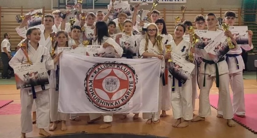 Karatecy ze stosem pucharów i medali