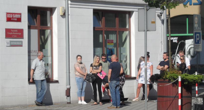Skarbówka boi się wirusa. Ludzie stoją na ulicy 