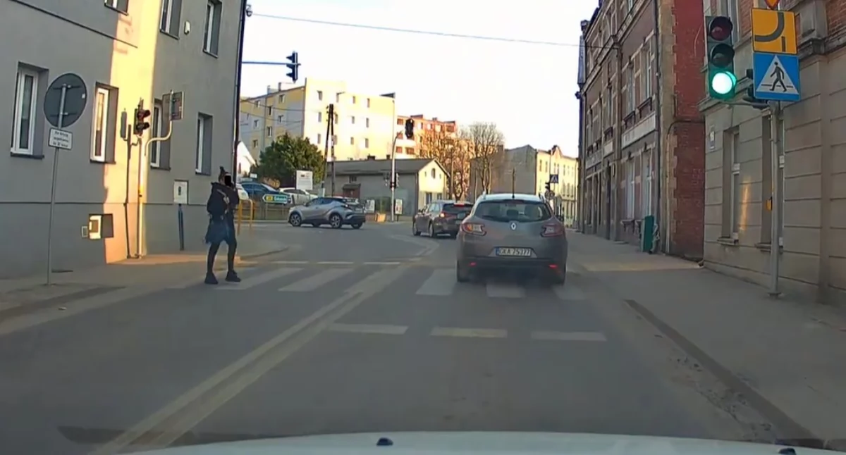 Telefon w ręku, czerwone światło nad głową. Niebezpieczna moda na pasach
