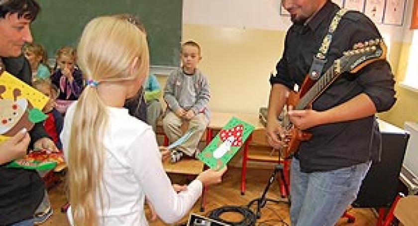 Dzieciaki próbowały swoich sił na gitarze. Spotkanie z muzykiem Michałem Munchem