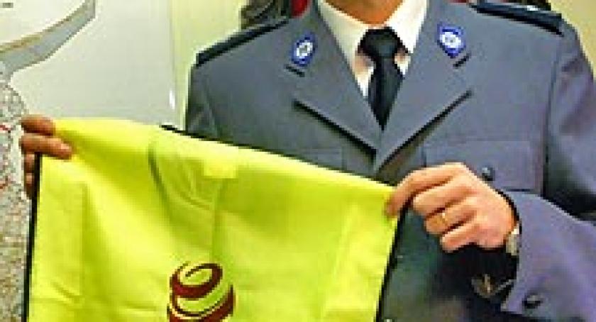 Policjanci rozdają kamizelki i elementy odblaskowe. 