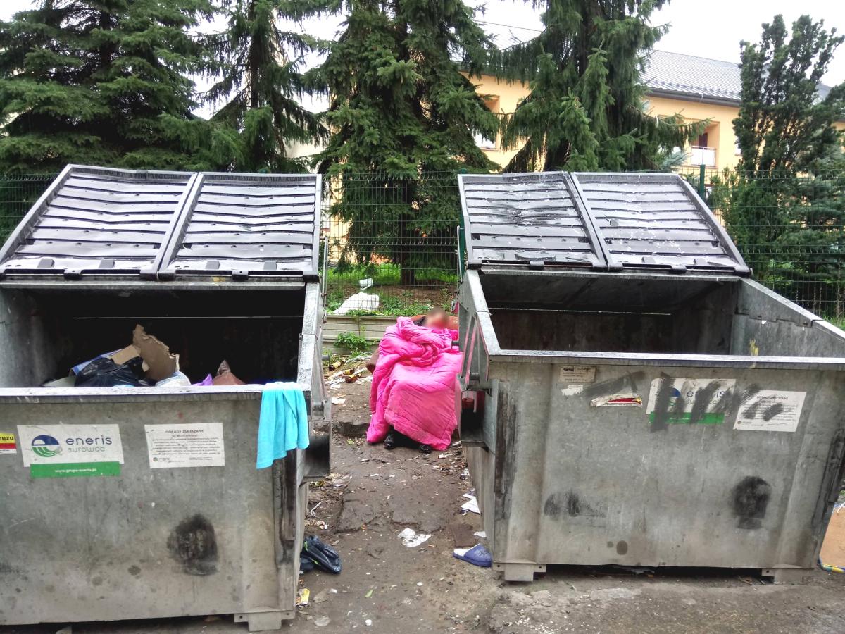 Bezdomni koczują na śmietniku