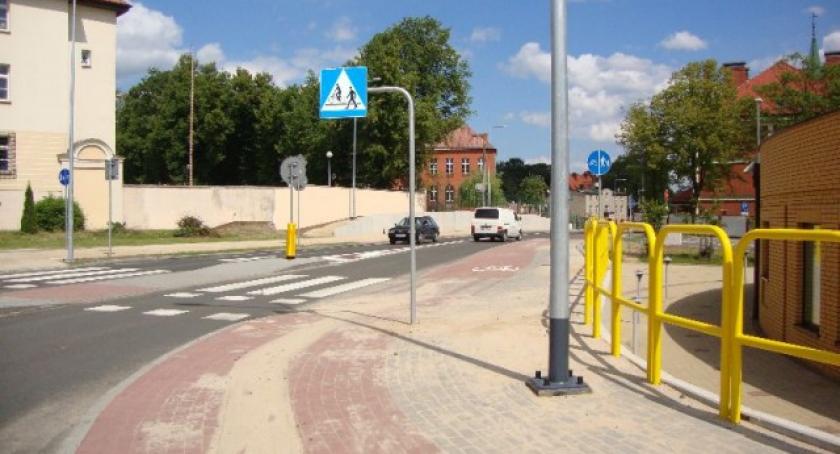Słup oświetleniowy i znak na... środku chodnika