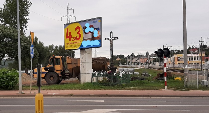 Profanacja w dolnych Starachowicach? Wielka reklama tuż obok zabytkowego krzyża