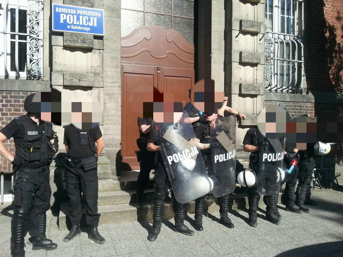 Kibice i policja pod wejściem do komendy