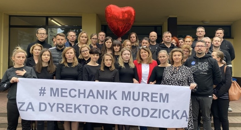 Nauczyciele Mechanika murem za dyrektor Grodzicką. Ubrani na czarno, z poważnymi minami, pozują do zdjęcia