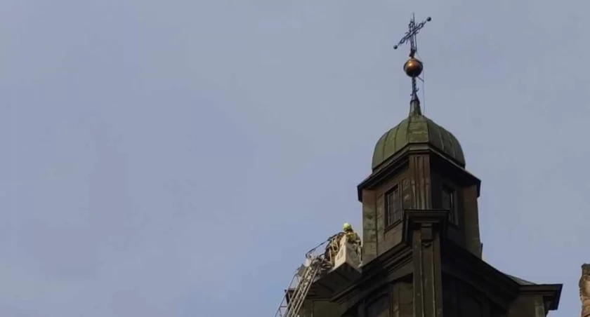 Strażacy zabezpieczają krzyż na wieży klasztoru Dominikanów w Gidlach. Potrzebny jest większy podnośnik z Warszawy