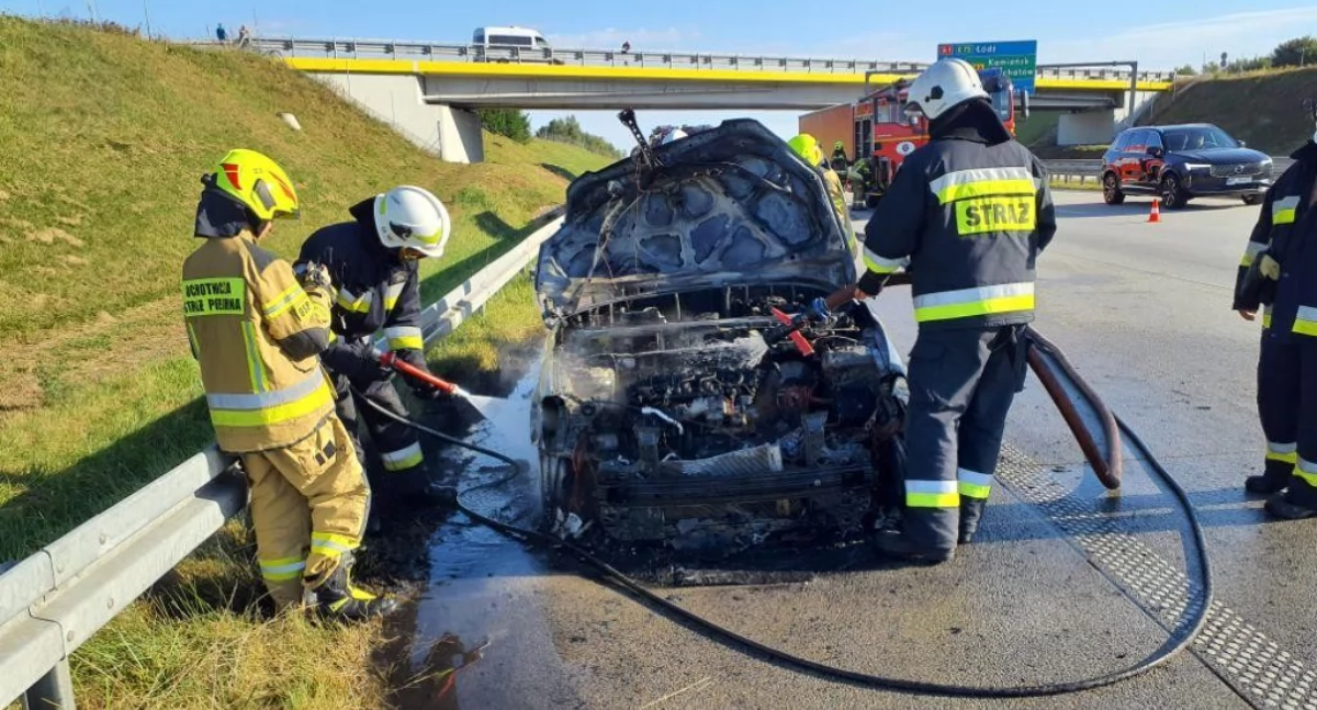 Pożar samochodu osobowego na autostradzie A1. Auto stoi na pasie awaryjnym