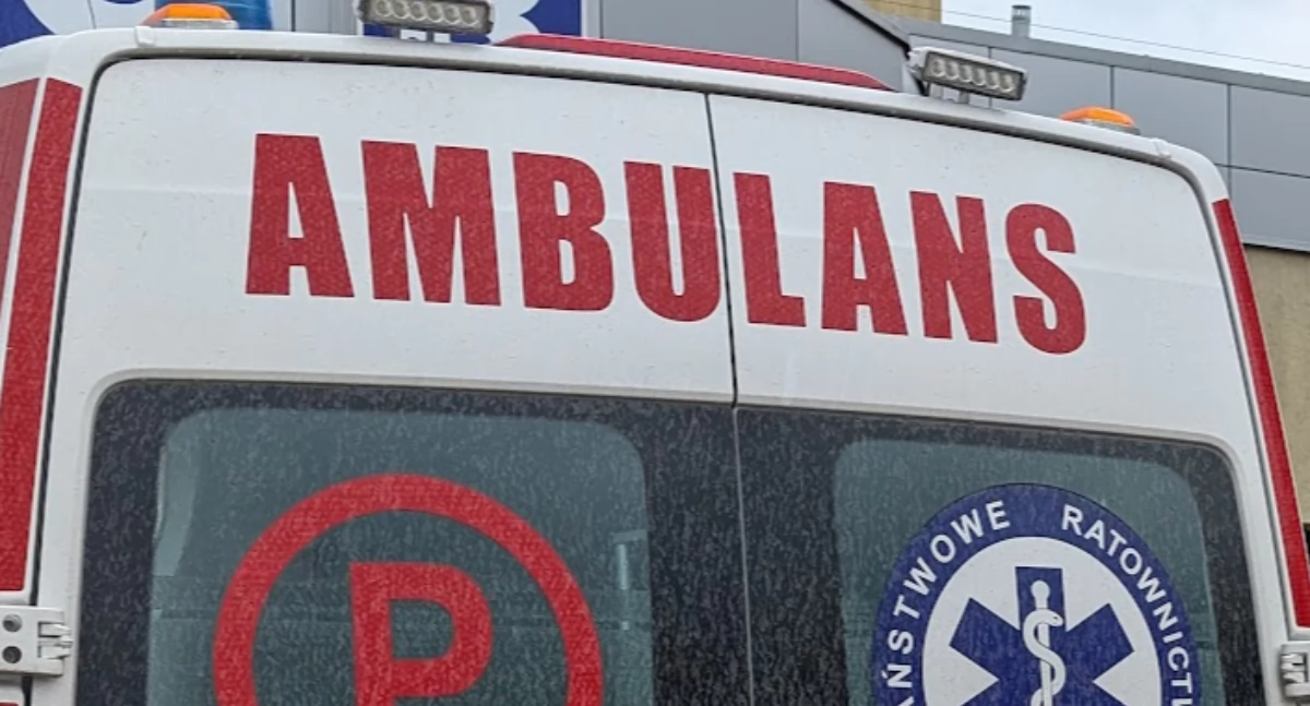 Ratownicy udzielali pomocy pacjentowi, a karetka powoli zapadała się w miękki trawnik