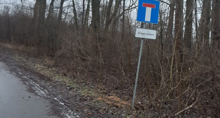Na zalewanej, nieprzejezdnej drodze do Szczepocic postawiono znak: droga zalana, brak przejazdu