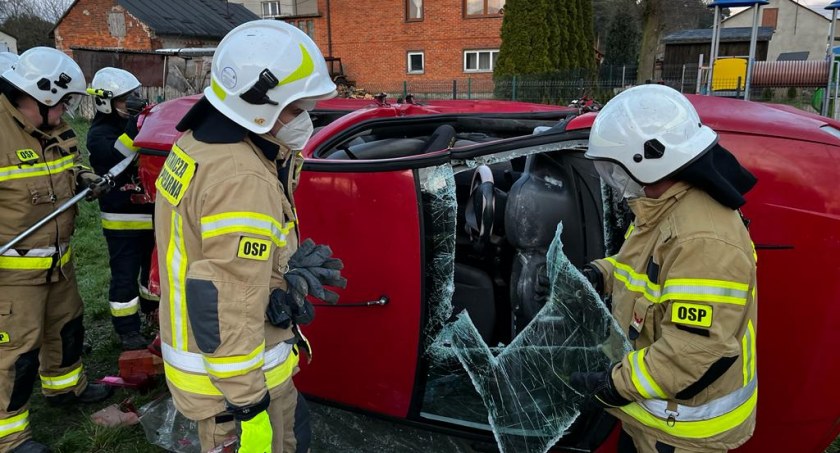Zdarzył się wypadek, samochód leży na boku, kierowca nie może się wydostać. Do akcji przystępują strażacy z Folwarek i Suchej Wsi