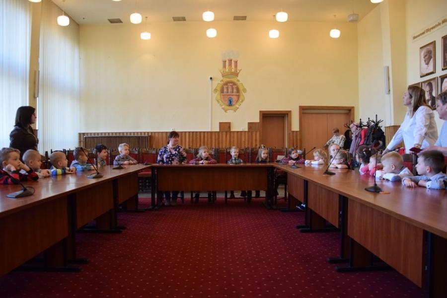 Dzieci wraz z prezydentem w sali obrad. Wizyta przedszkolaków w Urzędzie Miasta