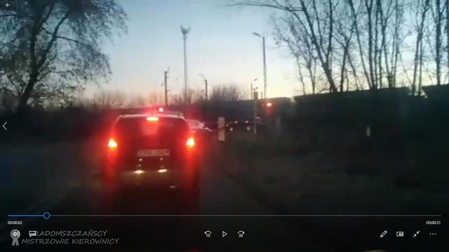 [FILM] Auto zablokowane między szlabanami, obok przejeżdża pociąg towarowy