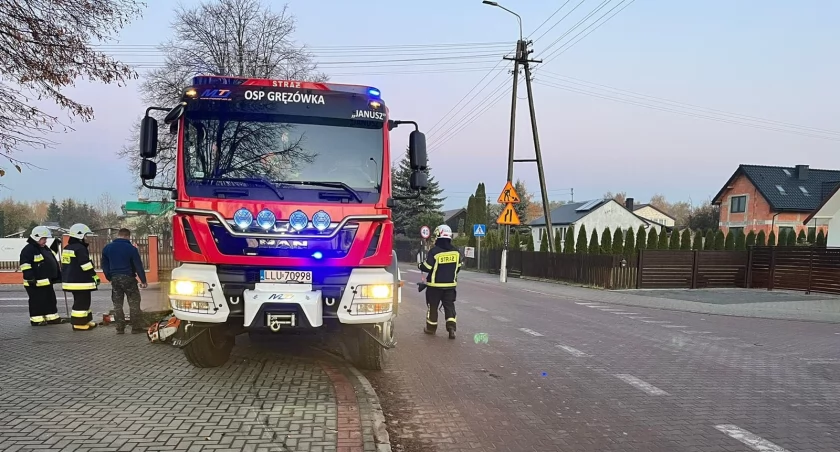 Strażacy z OSP Gręzówka usuwają przewrócony betonowy słup na jezdnię 