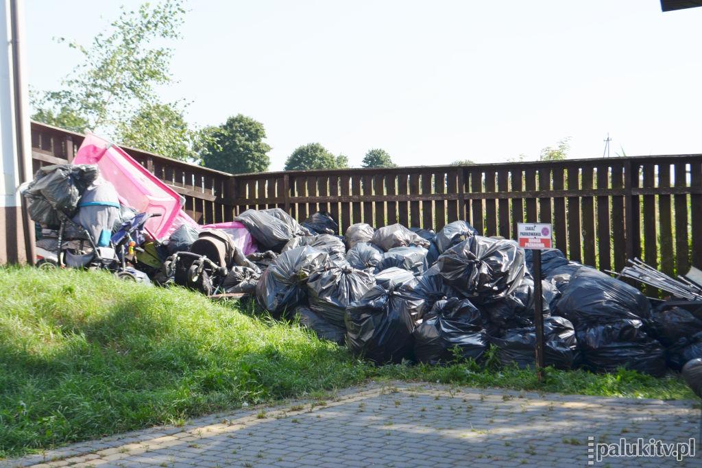 Duża ilość worków na śmieci, wózki i różowe łóżeczko na terenie ośrodka w Biskupinie