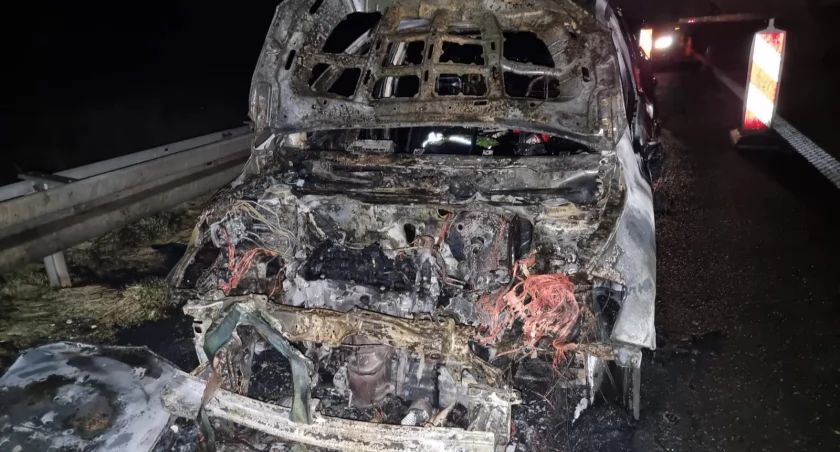 Płonące auto na drodze
