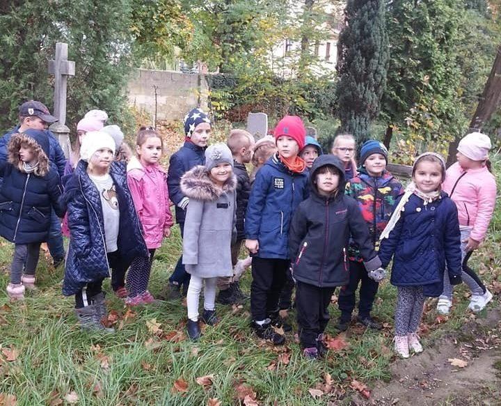 Przedszkolaki sprzątają groby