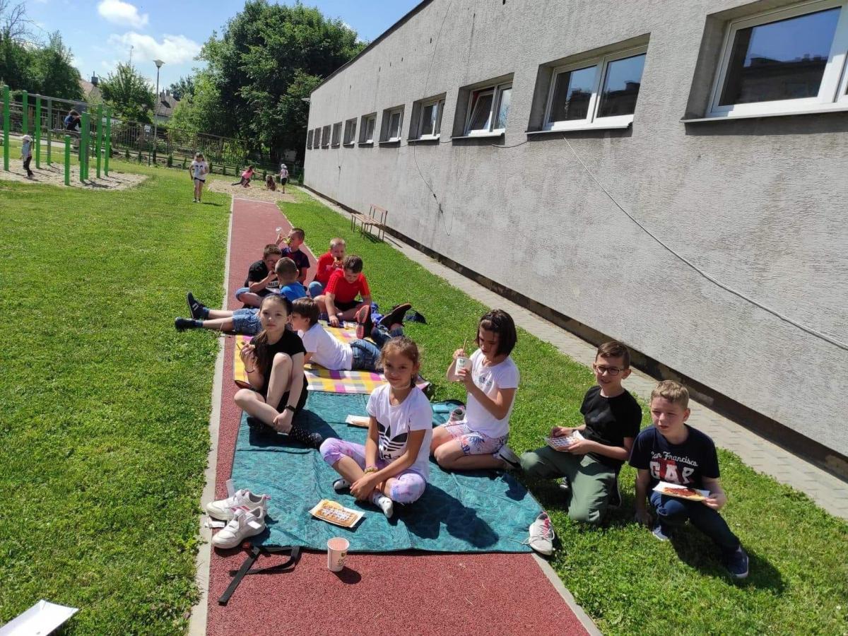 Śniadanie na trawie na szkolnym podwórku