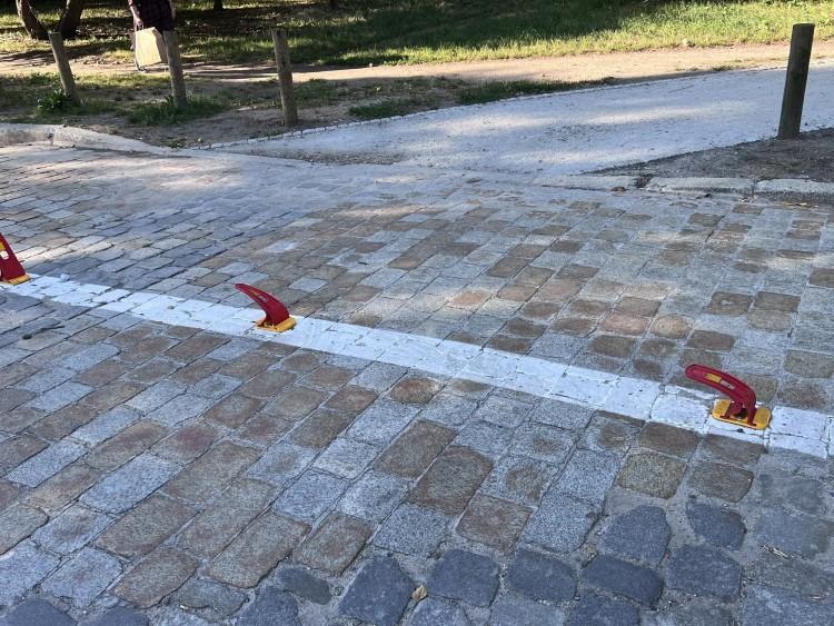 Chodnik z kawałka jezdni i słupków. Kilka z nich już przejechano
