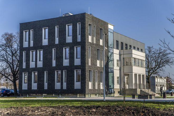 Nowy biurowiec z elewacją z koszy gabionowych wypełnionych kostką granitową 
