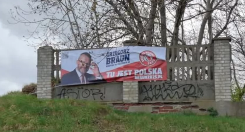 Baner wyborczy Grzegorza Brauna na ogrodzeniu cmentarza żydowskiego. Prowokacja?