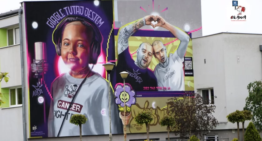 Maja patrzy na mural ze swojego okna. 