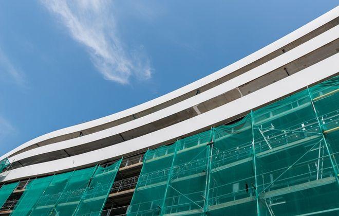 Montują corian na budowie olbrzymiego gmachu w centrum. Obła elewacja będzie śnieżnobiała