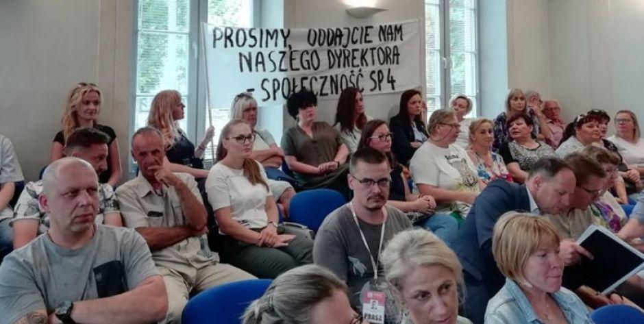 Rodzice i nauczyciele z transparentem na sesji 
