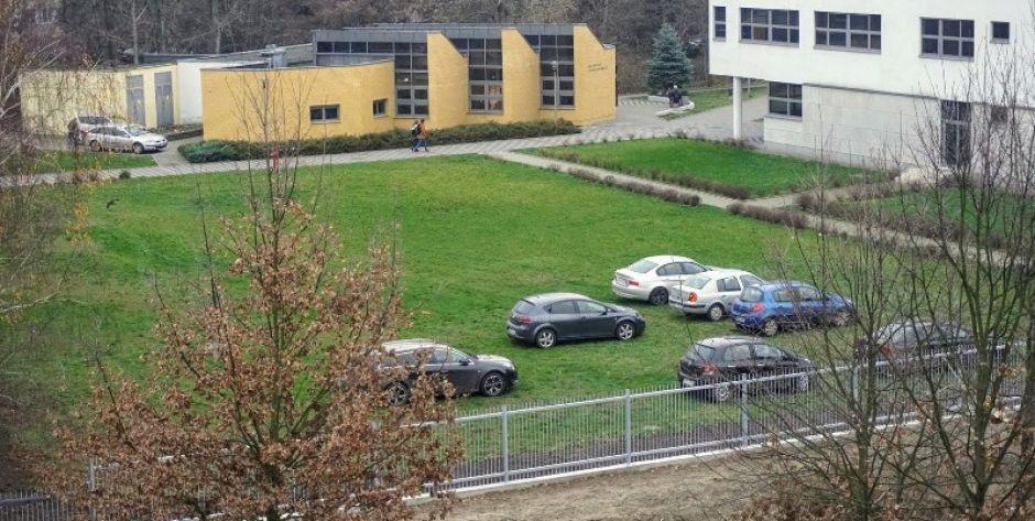 Studenci skaczą przez płot 