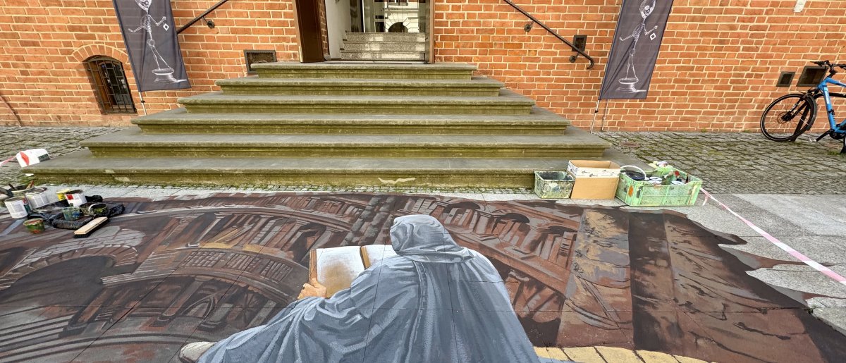 Przed schodami Biblioteki Elbląskiej pojawił się mural 3D. Ma zachęcić do odwiedzenia Interaktywnej Wystawy Dawnej Książki i Prasy „ElKamera”.