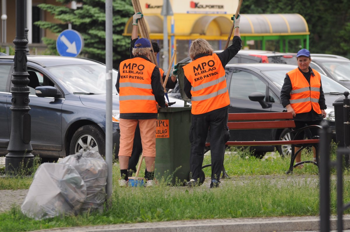 Kobiety pucują wiaty, mężczyźni zamiatają chodniki