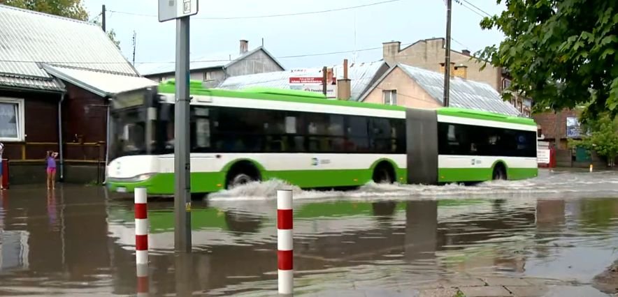Autobus na wodzie i piesi na bosaka. Krajobraz po burzy w Białymstoku