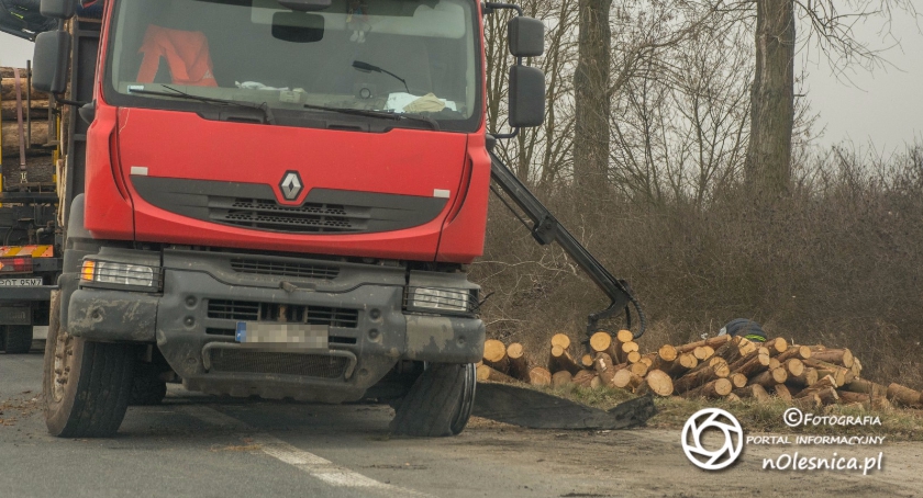 Pęknięta opona i transport drzewa w rowie