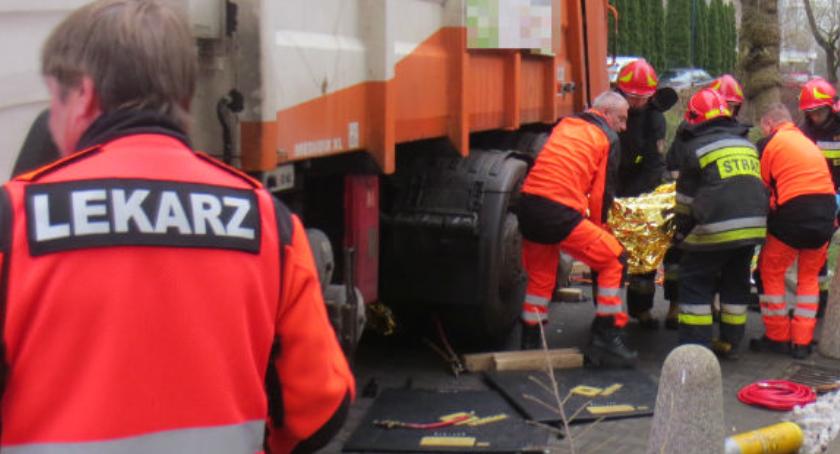 Mężczyzna przygnieciony przez śmieciarkę. Akcja straży na zdjęciach