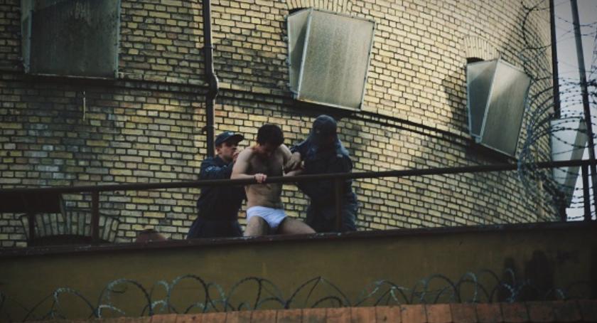 Więzień w samych majtkach na murze aresztu! Jak on tam się dostał? [FOTO]